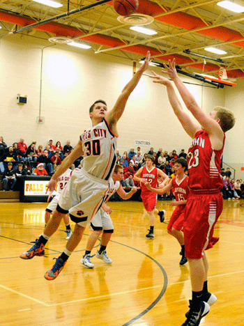 Falls City High senior Ryan Mount contests an Auburn shooter Friday night in the Tigers’ 64-28 win. Mount made 6-of-7 free throws in the game and is 11-of-13 at the stripe so far this season. Falls City has now won 21 in a row over the Bulldogs, dating back to 2005. Photo by Dave Davis.