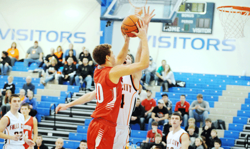 	Falls City High junior Jack Hartman challenges Auburn senior Caleb Nelson’s shot attempt Saturday night during the first quarter of the Tigers 45-34 victory at Peru. Hartman recorded the block on the play and finished the night with 11 points and a team-high eight rebounds.  The Tigers win marked 22-straight victories over the Bulldogs and claimed the championship of the Southeast Nebraska Tournament, hosted by Peru State College. FC’s Mitchell Harling (left) and Tyler DiGiacomo are also pictured. Photo by Jim Langan.